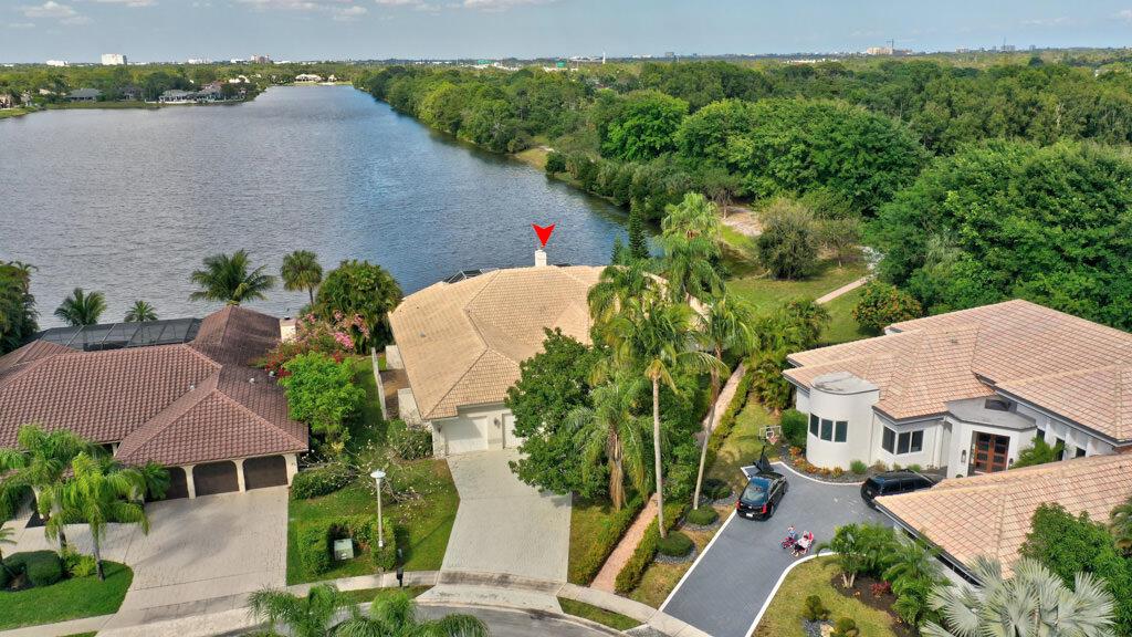An aerial view of three suburban houses near a lake with a red arrow pointing upward — 1823 SW 17th Street, Boca Raton FL 33486, BOCA RATON, FL