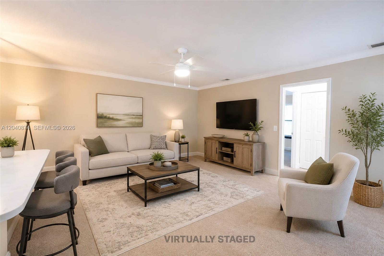 This living room features a sofa, armchairs, a coffee table, and a wall-mounted television — 1188 Breezy Way # 6D, Sebastian FL 32958, SEBASTIAN, FL