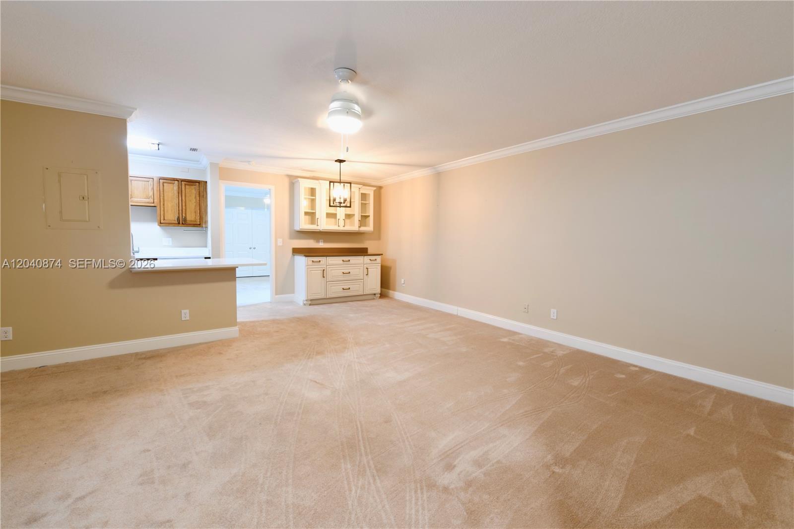 A carpeted living area features a breakfast bar, built-in cabinetry, and a ceiling fan — 1188 Breezy Way # 6D, Sebastian FL 32958, SEBASTIAN, FL