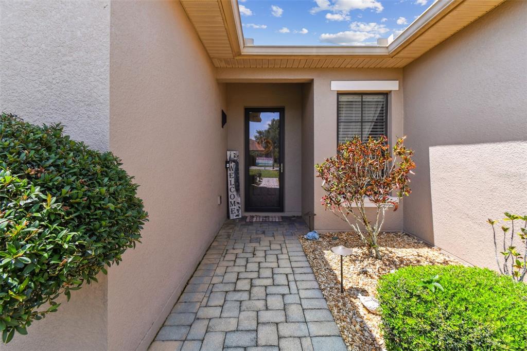 A paved walkway leads to a front door with a welcome sign and landscaping — 429 VILLA PARK ROAD, KISSIMMEE, FL