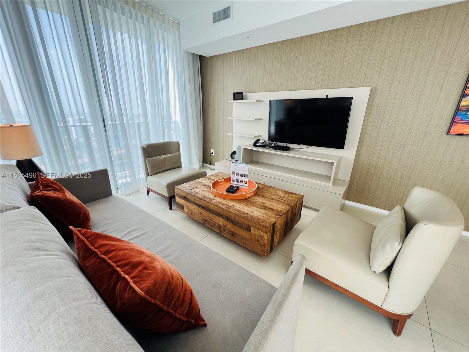 A modern living room features a gray sofa, two armchairs, and a wooden coffee table — 4111 S Ocean Dr # 2611, Hollywood FL 33019, HOLLYWOOD, FL