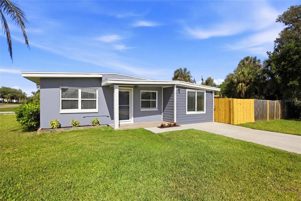 A gray single-story house with a wooden porch and a wooden fence on the side — 3927 VASCO STREET, PUNTA GORDA, FL