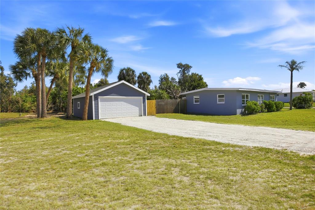 A detached garage and a single-story house sit on a large, grassy lot — 3927 VASCO STREET, PUNTA GORDA, FL