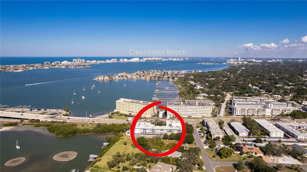 An aerial view shows a multi-story residential building circled in red near a waterfront — 50 HARBOR VIEW LANE UNIT 11, BELLEAIR BLUFFS, FL