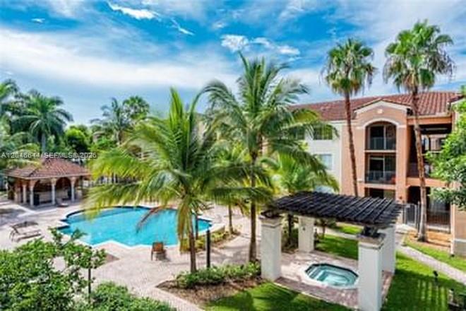 An outdoor swimming pool and a covered hot tub are situated beside a multi-story building — 6841 SW 44th St # 204, Miami FL 33155, MIAMI, FL