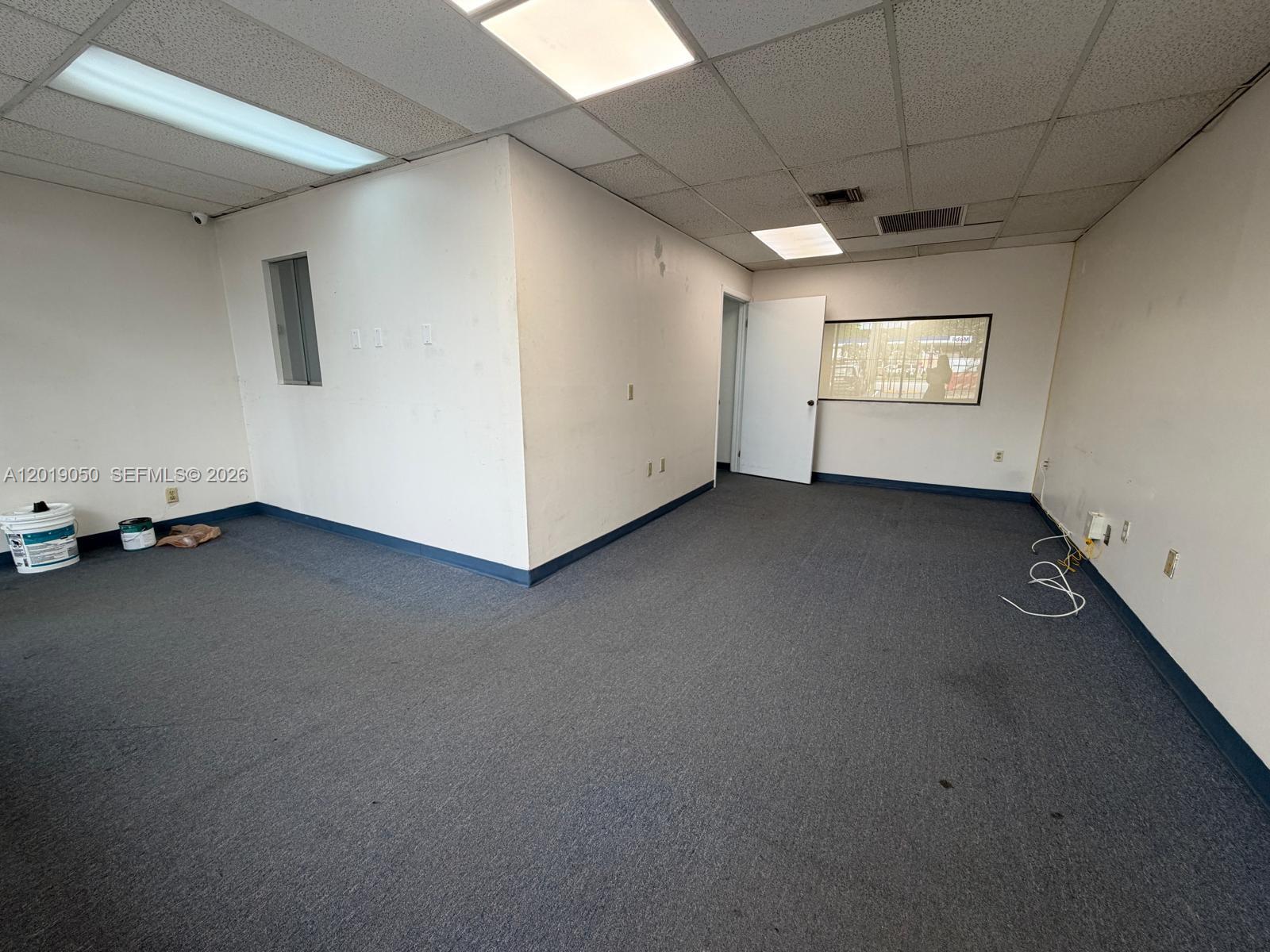 An empty office space features gray carpeting, white walls, a drop ceiling, and a doorway — 2501 NW 72nd Ave # B, Miami FL 33122, MIAMI, FL