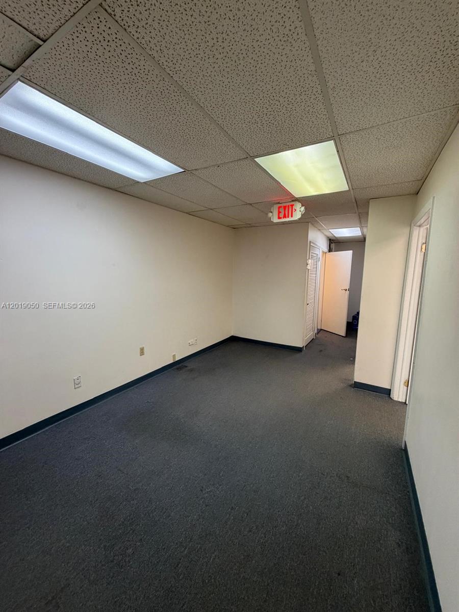 An empty office space features beige walls, gray carpeting, and a drop ceiling with lights — 2501 NW 72nd Ave # B, Miami FL 33122, MIAMI, FL