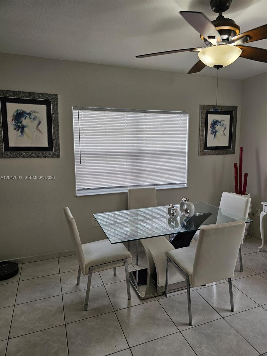 A dining room features a glass-top table, four white chairs, and a ceiling fan — 7565 N Augusta Dr # 7567, Hialeah FL 33015, HIALEAH, FL