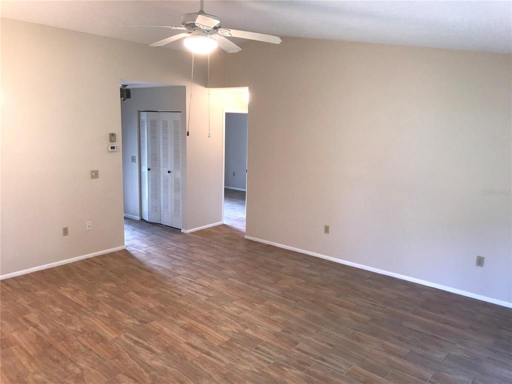 An empty room with light-colored walls, wood-look tile flooring, and a ceiling fan — 3705 34TH AVE DRIVE W, BRADENTON, FL