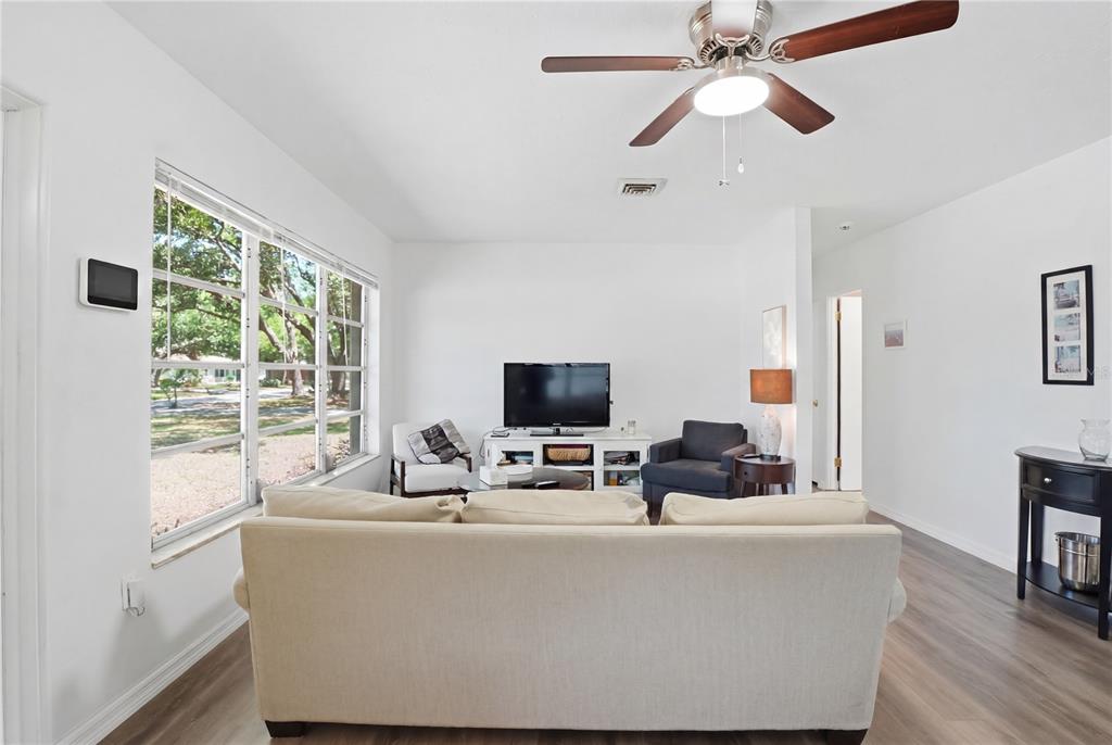 A living room features a beige sofa, a television on a stand, and a ceiling fan — 73 SAINT LUCIE AVENUE, SARASOTA, FL