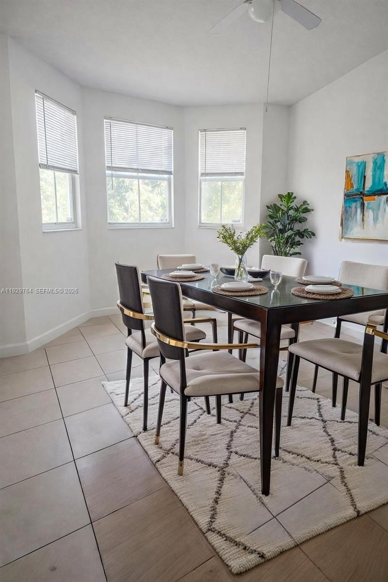 A dining room features a dark wood table, upholstered chairs, and a white area rug — 2811 SE 17th Ave # 210, Homestead FL 33035, HOMESTEAD, FL
