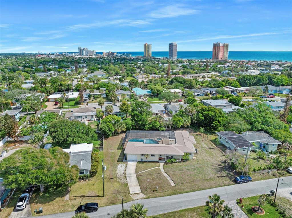 An aerial view shows a single-story house with a screened pool and a large yard — 307 MANHATTAN AVENUE, DAYTONA BEACH, FL