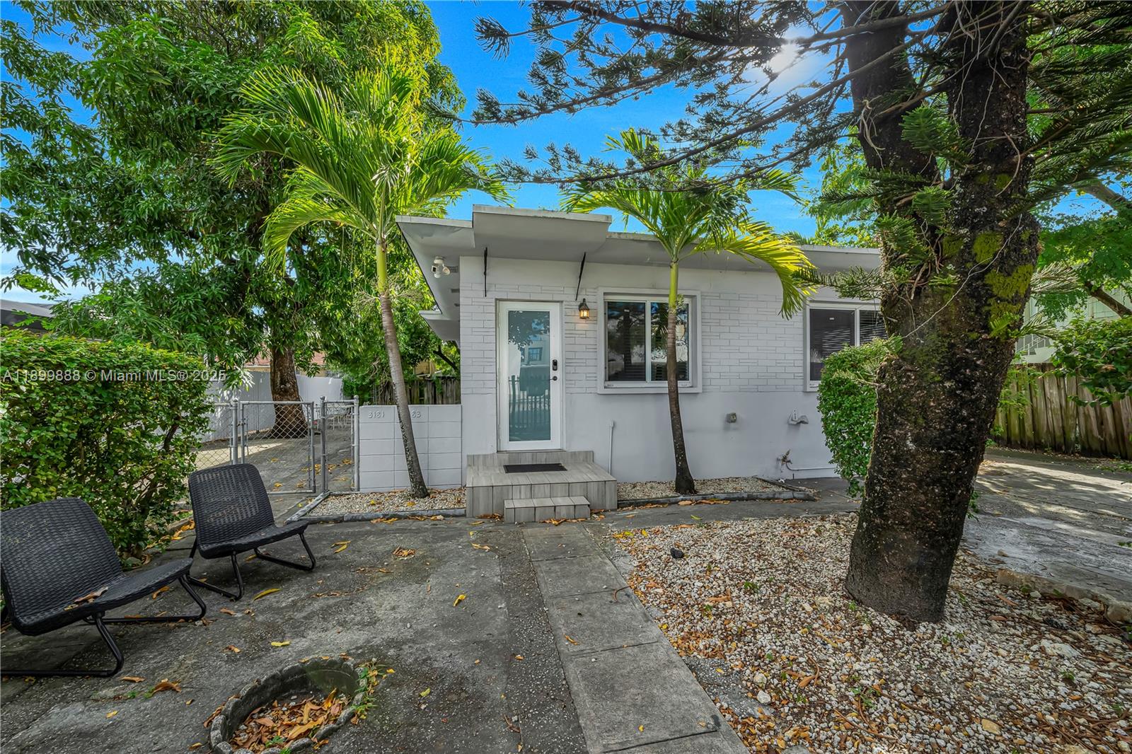 A white, single-story house with a flat roof, palm trees, and a small front patio — 3181 NW 5th Ave, Miami FL 33127, MIAMI, FL