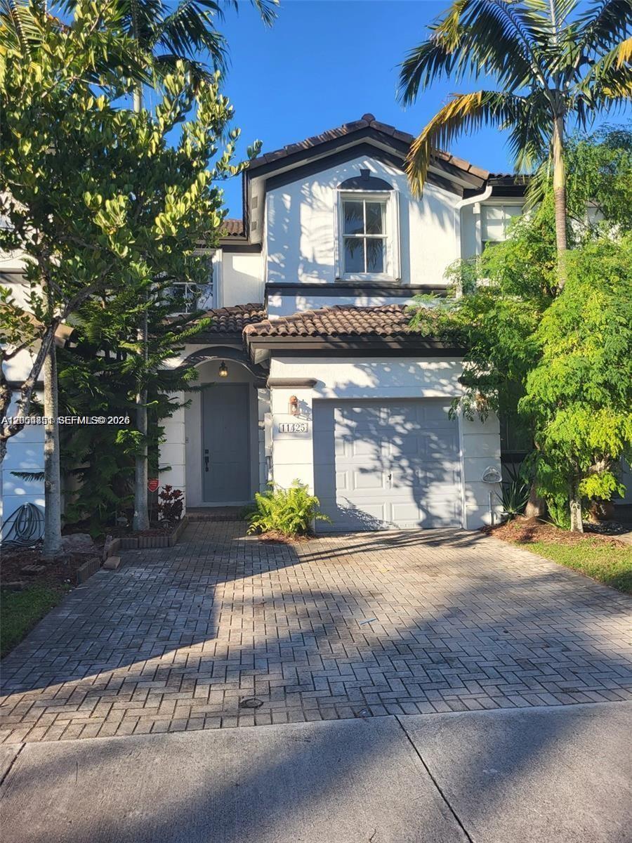 A two-story house with a paved driveway, a single-car garage, and a gray front door — 11425 NW 76th Ter, Doral FL 33178, DORAL, FL