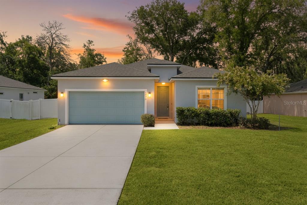 A single-story house with a light gray exterior, a two-car garage, and a concrete driveway — 8578 SE 164TH PLACE, SUMMERFIELD, FL