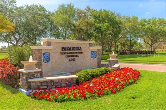 A stone monument sign for Pasadena Yacht & Country Club sits in a landscaped garden — 5950 PELICAN BAY PLAZA S UNIT 705, GULFPORT, FL