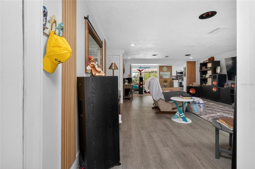 A view from a doorway into a living room with wood-look flooring and audio equipment — 625 SANDPIPER LANE, NOKOMIS, FL