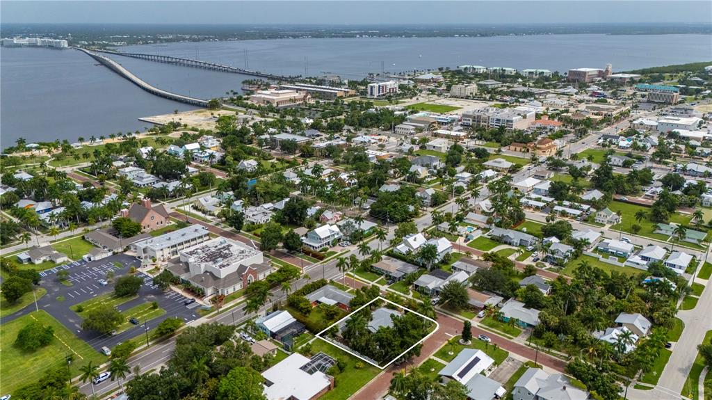 An aerial view shows a residential neighborhood with a highlighted house near a large bridge — 311 GILL STREET, PUNTA GORDA, FL