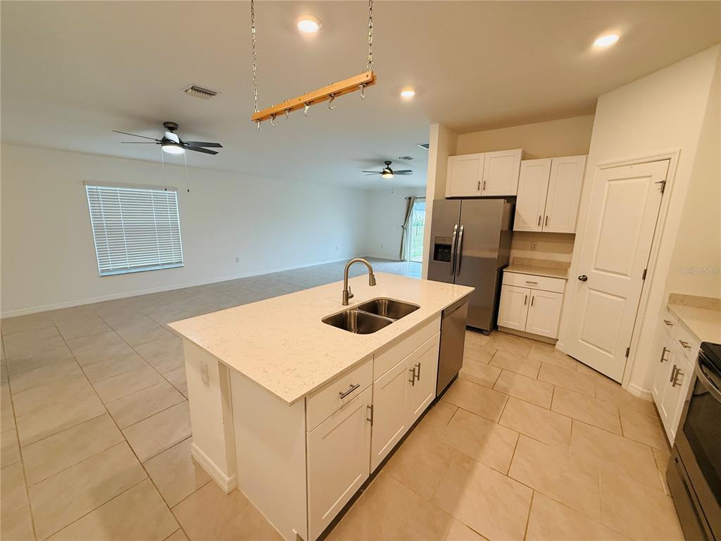 A kitchen with a white island, stainless steel appliances, and tile flooring in an open space — 4034 SAN CLEMENTE COURT, NORTH FORT MYERS, FL