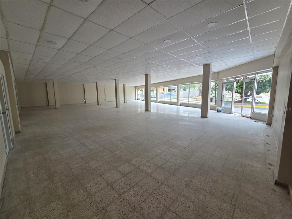 An empty commercial space features a drop ceiling, tiled floors, and large windows — 1 TOMÁS DÁVILA MARTÍNEZ, BARCELONETA, PR