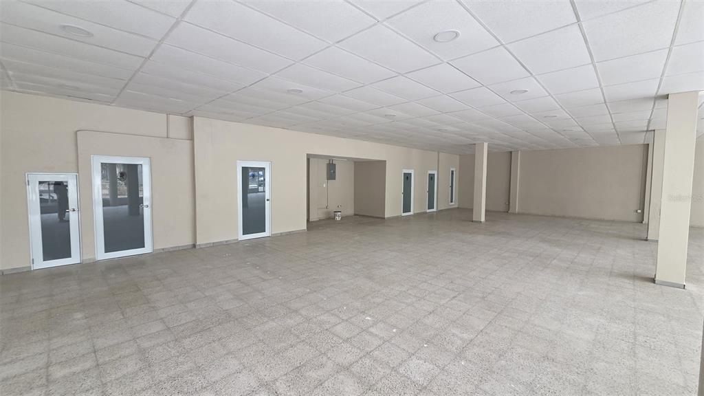 An empty commercial space with tiled floors, a drop ceiling, and several white-framed doors — 1 TOMÁS DÁVILA MARTÍNEZ, BARCELONETA, PR