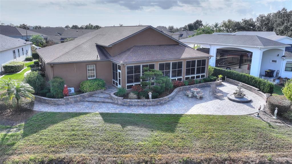An aerial view of a house with a screened-in porch and a paved patio area — 370 MEANDERING WAY, POLK CITY, FL