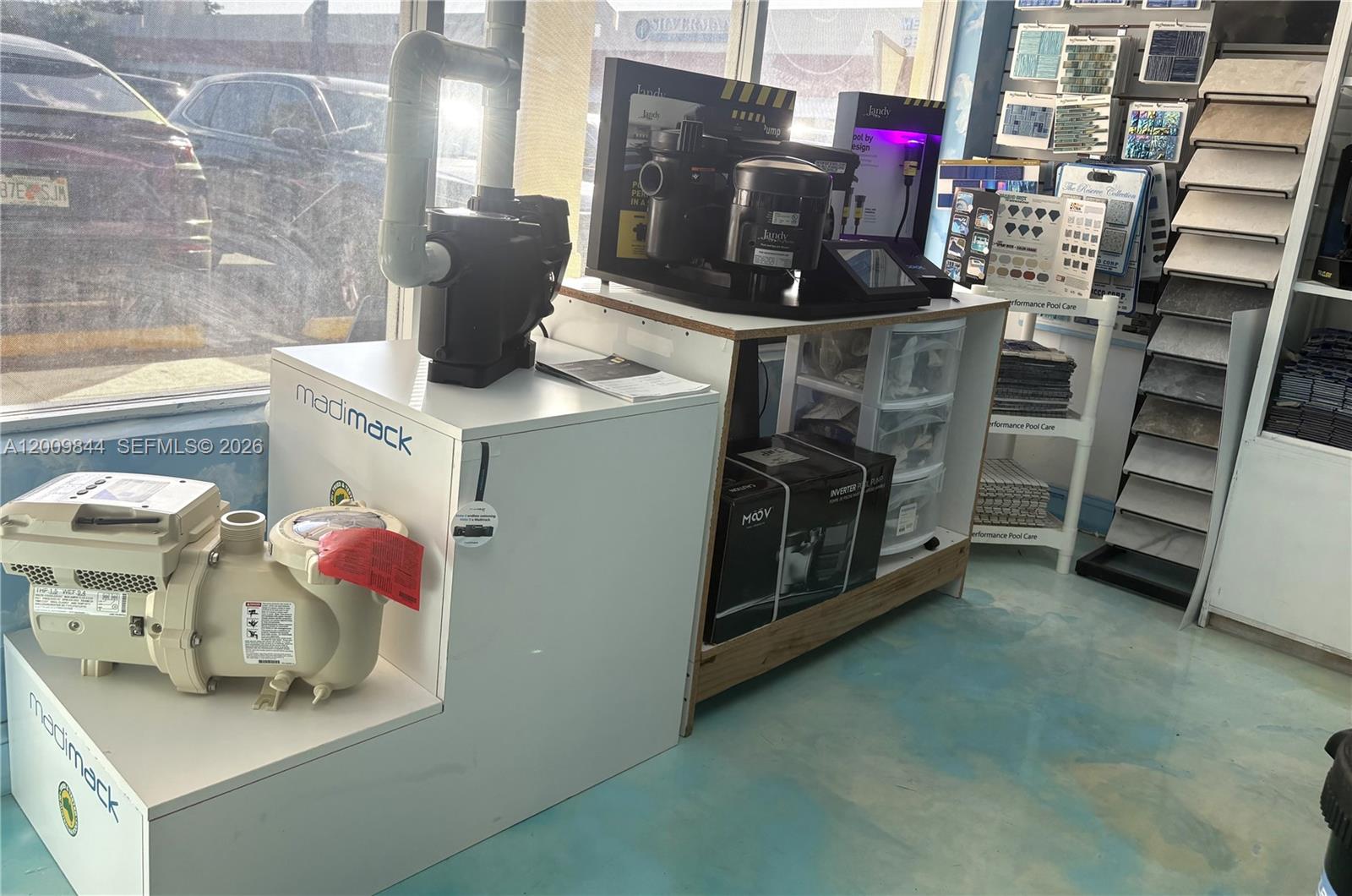 A retail showroom displays pool equipment, including pumps and tile samples on shelves — 82 SW 8, Miami FL 33144, MIAMI, FL