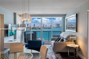 A living room with a dining area, modern lighting, and a balcony overlooking the water — 1900 Sunset Harbour Dr # 1012, Miami Beach FL 33139, MIAMI BEACH, FL