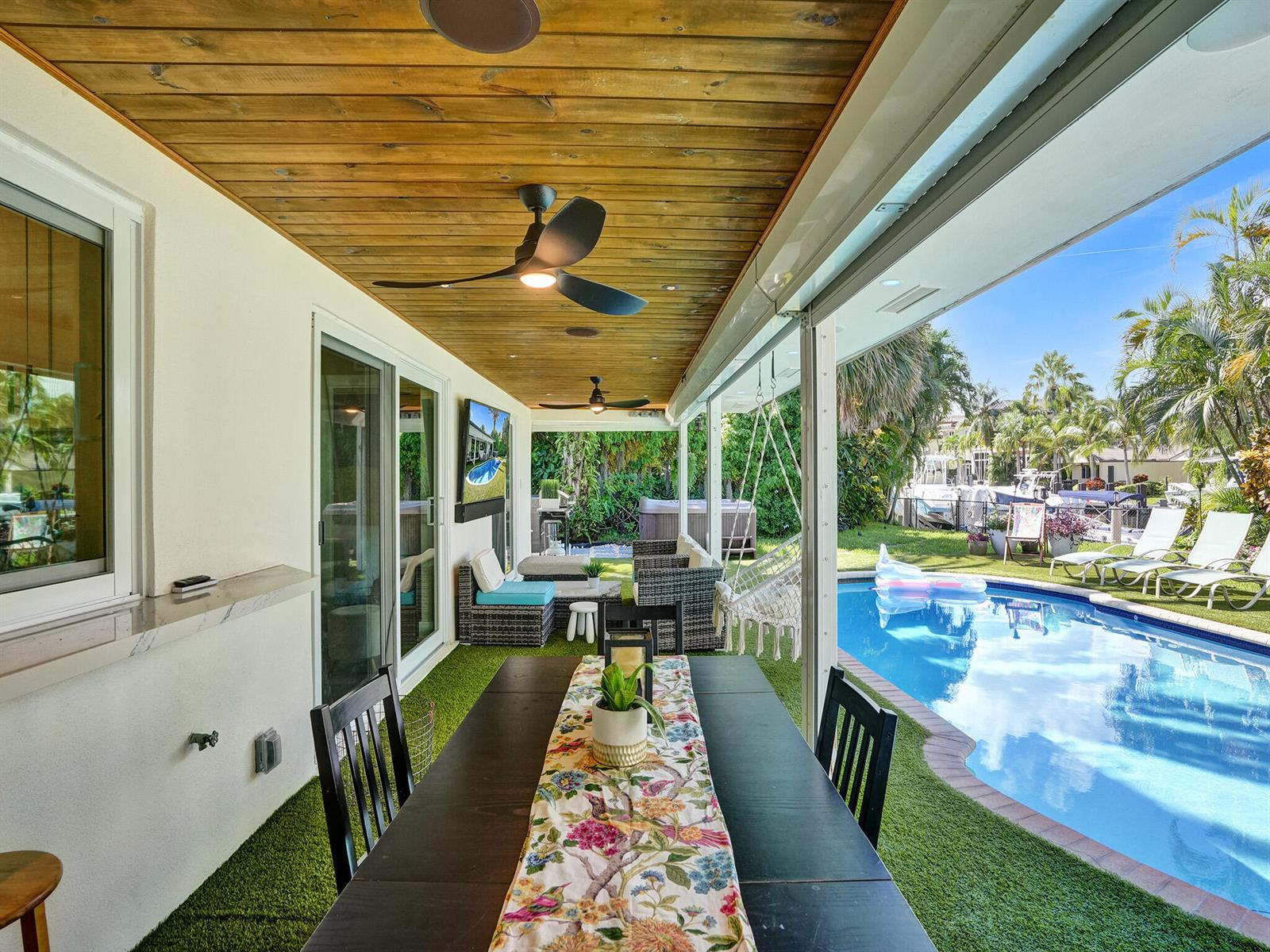 A covered patio features a dining table, ceiling fans, and a view of a swimming pool — 3821 NE 29th Avenue, Lighthouse Point FL 33064, LIGHTHOUSE POINT, FL