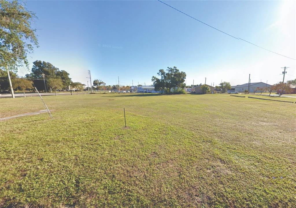 A wide, flat, grassy vacant lot under a clear blue sky — 1860 6TH STREET NW, WINTER HAVEN, FL