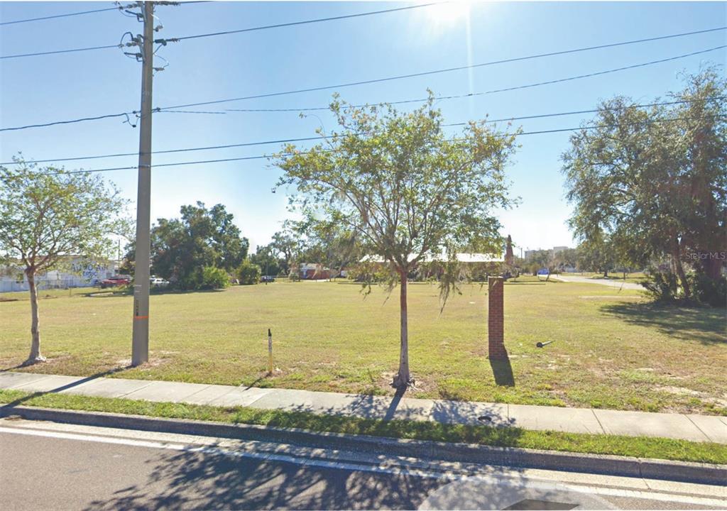 A vacant, grassy lot features a few scattered trees and a brick pillar — 1860 6TH STREET NW, WINTER HAVEN, FL