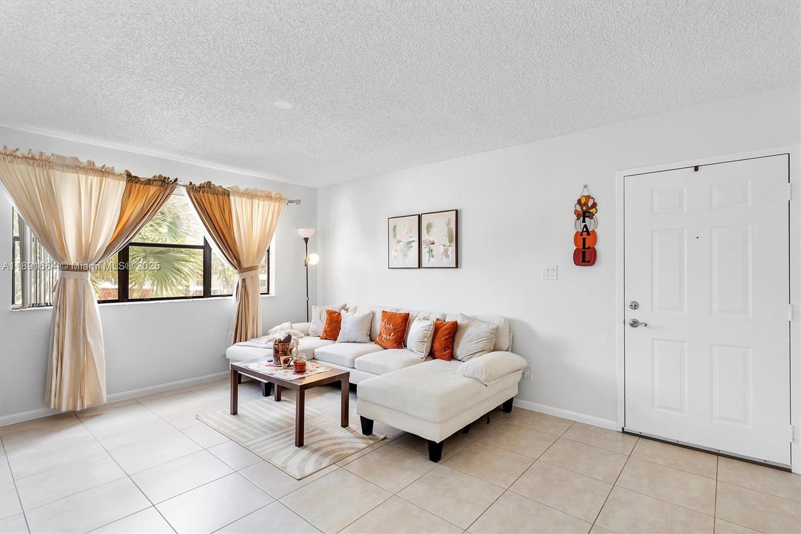 A living room features a white sectional sofa, a coffee table, and tile flooring — 510 S Park Rd # 10, Hollywood FL 33021, HOLLYWOOD, FL