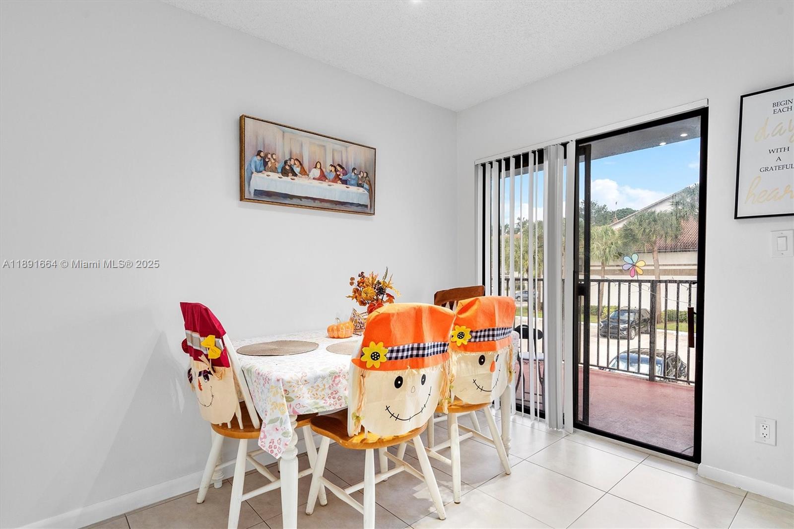 A dining area features a table with scarecrow-themed chair covers and a sliding glass door — 510 S Park Rd # 10, Hollywood FL 33021, HOLLYWOOD, FL