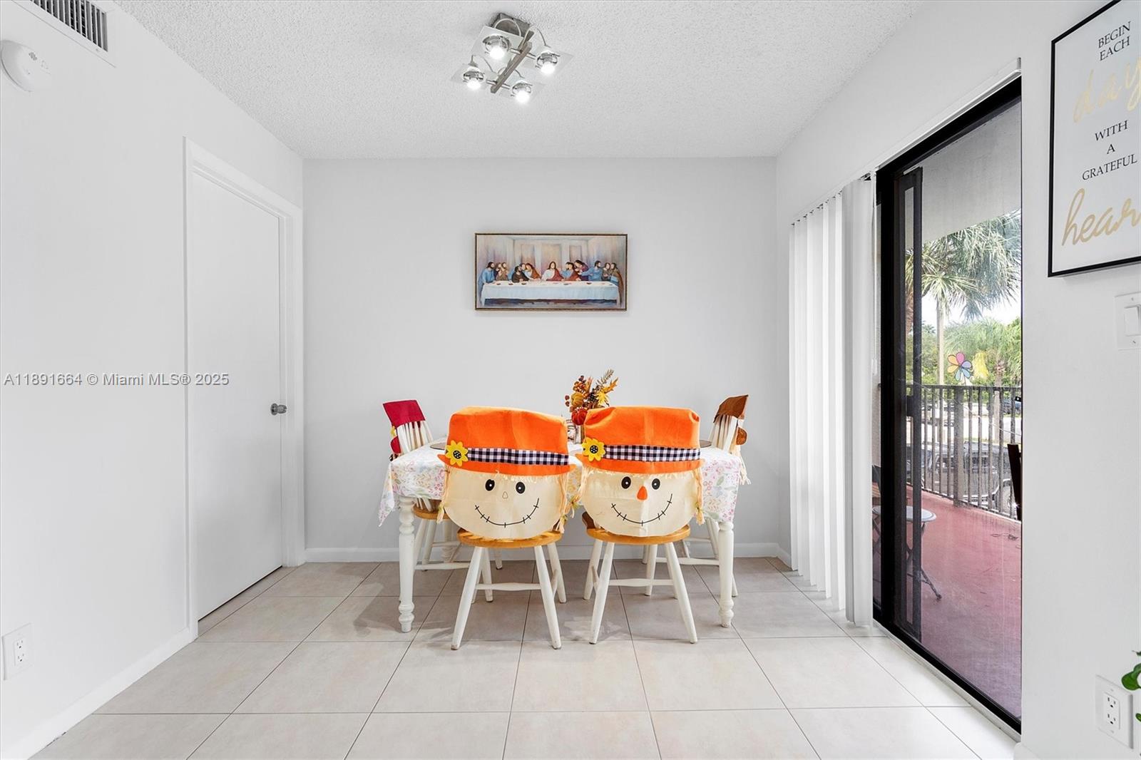 A dining area features a table with scarecrow-themed chair covers and tile flooring — 510 S Park Rd # 10, Hollywood FL 33021, HOLLYWOOD, FL