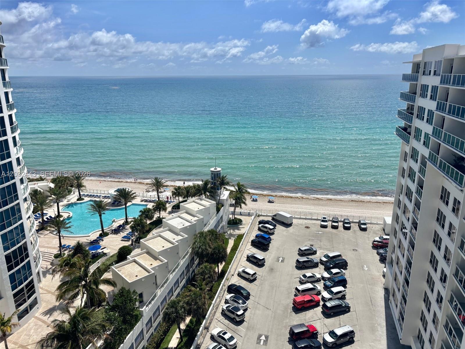 An elevated view shows a beach, ocean, swimming pool, and a parking lot between buildings — 3505 S Ocean Dr # 1506, Hollywood FL 33019, HOLLYWOOD, FL