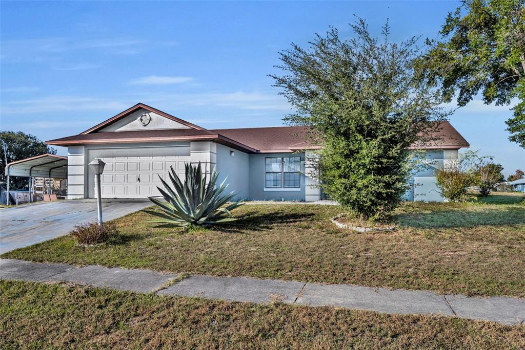 A single-story house with a two-car garage, a large agave plant, and a front lawn — 15215 SW 39TH CIRCLE, OCALA, FL