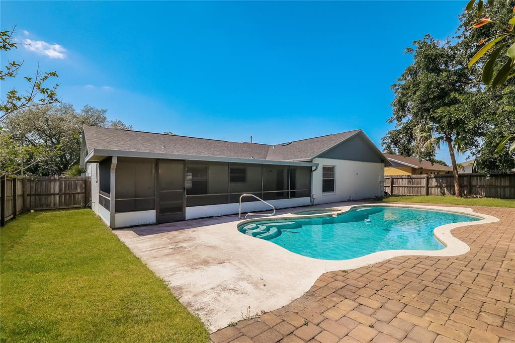 A backyard features a swimming pool, a screened-in patio, and a wooden privacy fence — 12013 CLOVE STREET, ORLANDO, FL
