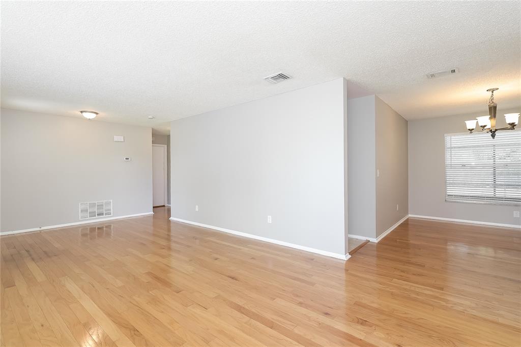 An open living and dining area with light hardwood floors and neutral gray walls — 12013 CLOVE STREET, ORLANDO, FL