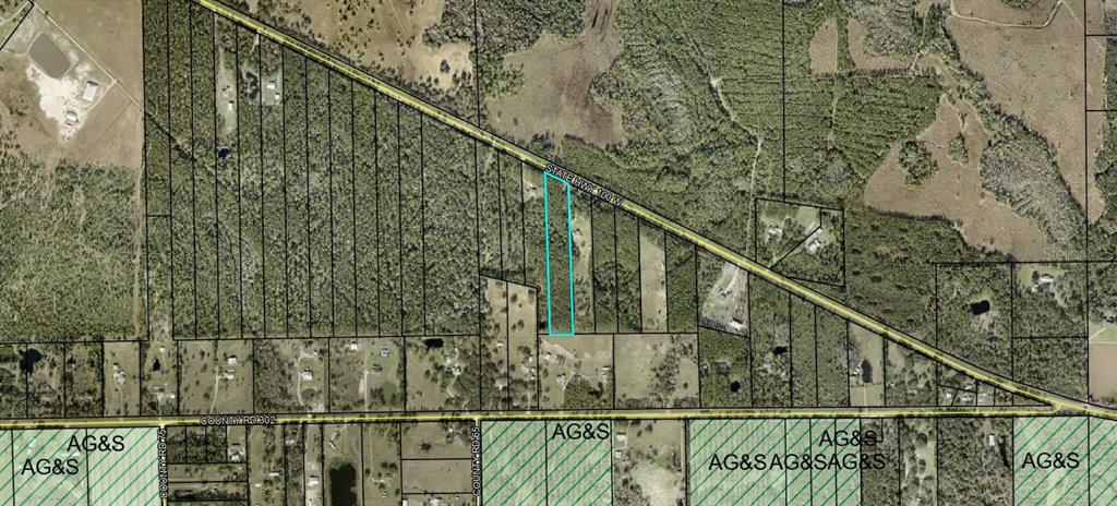 This aerial map shows a rectangular parcel of land outlined in blue along a highway — 4297 W HIGHWAY 100, BUNNELL, FL