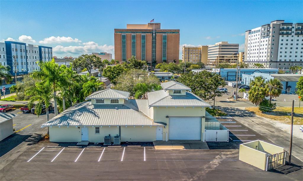 An aerial view of a light yellow commercial building with a metal roof and parking lot — 525 8TH STREET W, BRADENTON, FL