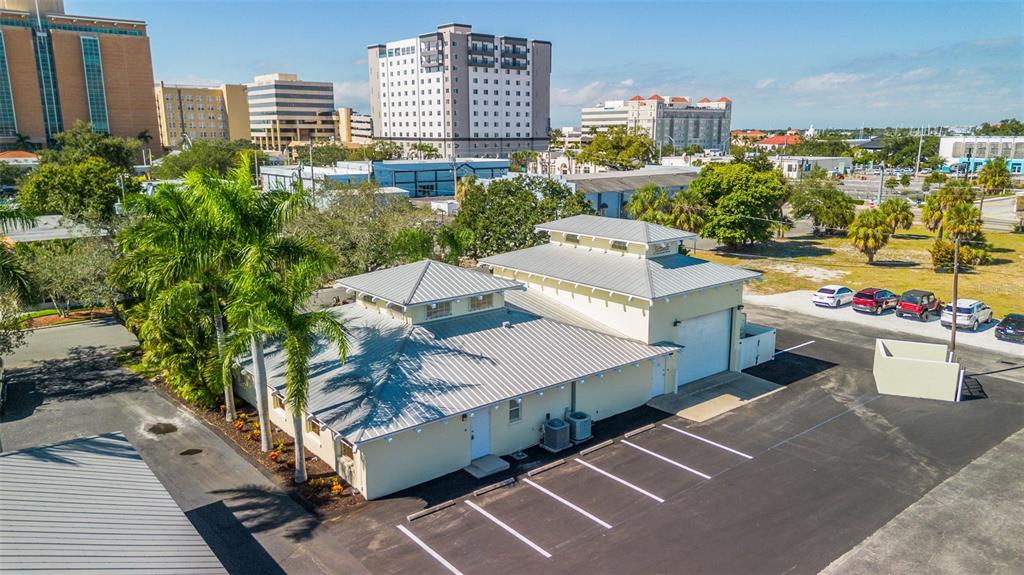 An aerial view of a light-colored commercial building with a metal roof and parking lot — 525 8TH STREET W, BRADENTON, FL