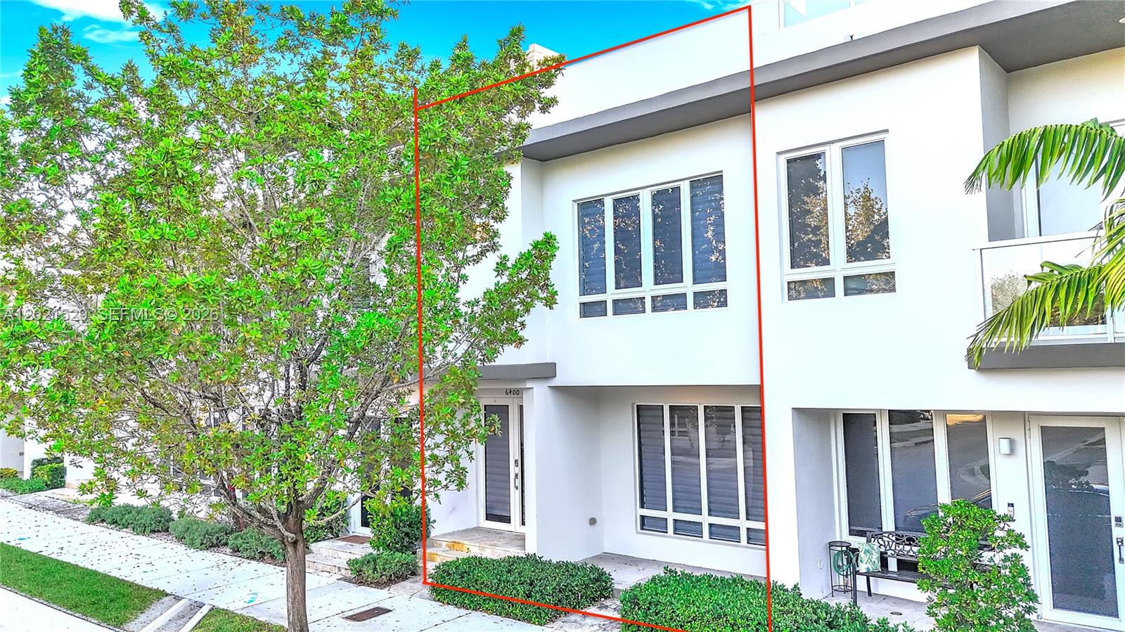 A two-story white townhouse exterior features large windows and a small front garden — 6400 NW 105th Pl, Doral FL 33178, DORAL, FL