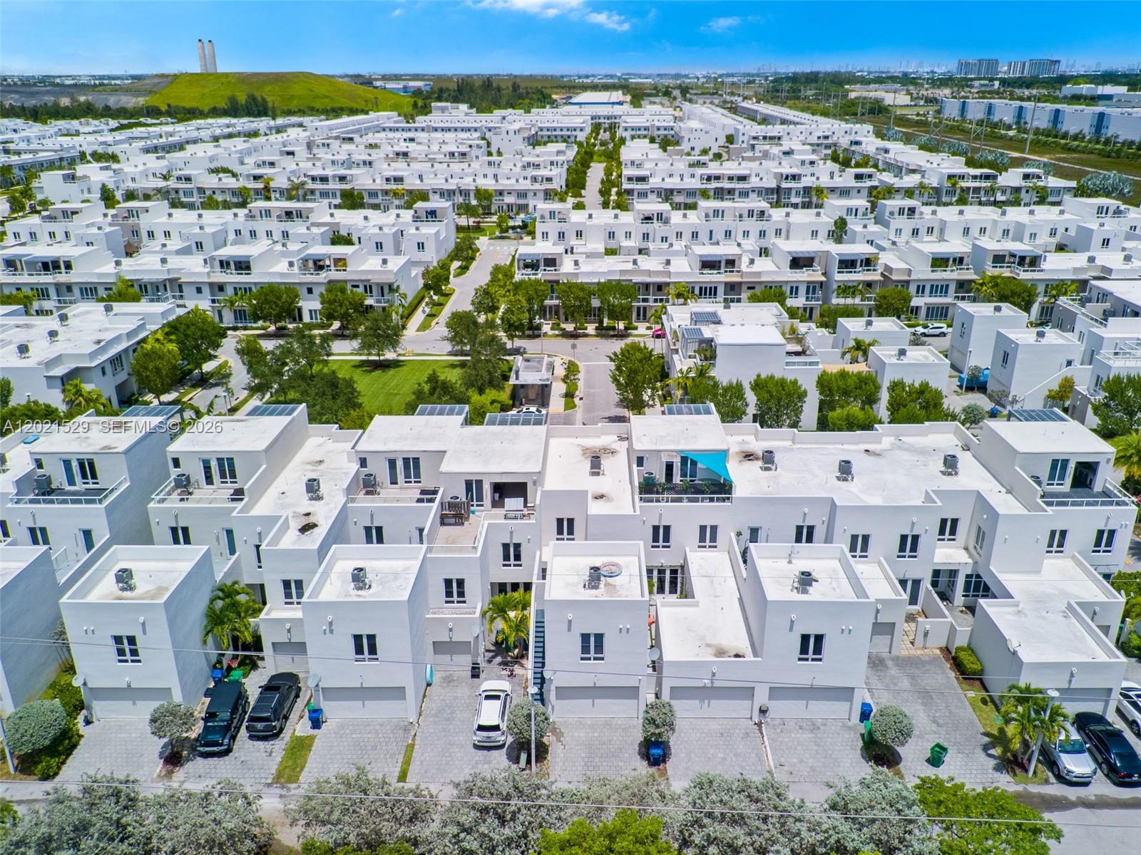 An aerial view shows a dense neighborhood of modern white townhouses with flat roofs — 6400 NW 105th Pl, Doral FL 33178, DORAL, FL