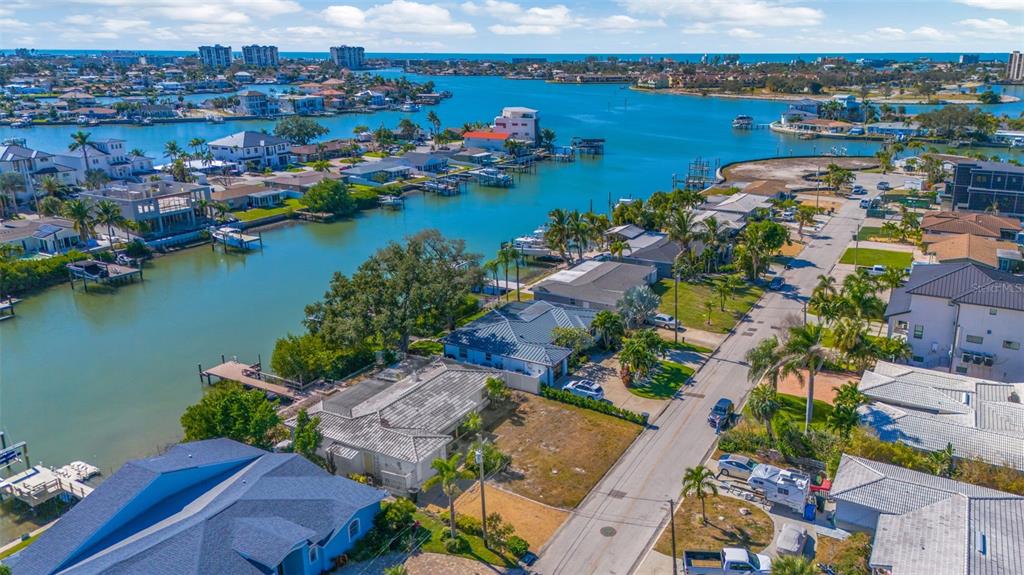 An aerial view shows waterfront houses along a canal with a street running alongside them — 7932 2ND AVENUE S, ST PETERSBURG, FL