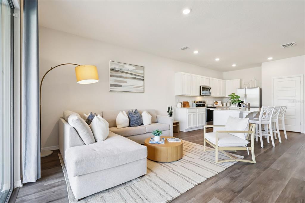 A living room with a sectional sofa, coffee table, and an open kitchen with island — 2618 OLYMPIC COURT, DAVENPORT, FL