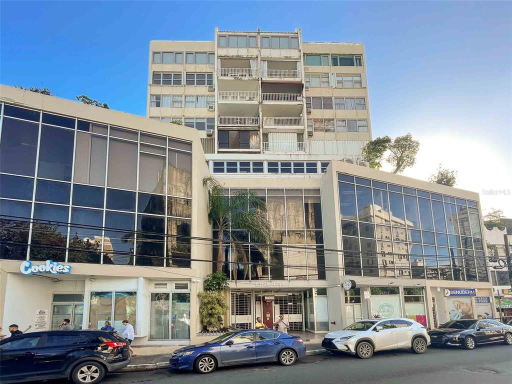 A multi-story building with a glass-fronted commercial base and residential balconies above — 1760 CALLE LOIZA UNIT 803, SAN JUAN, PR