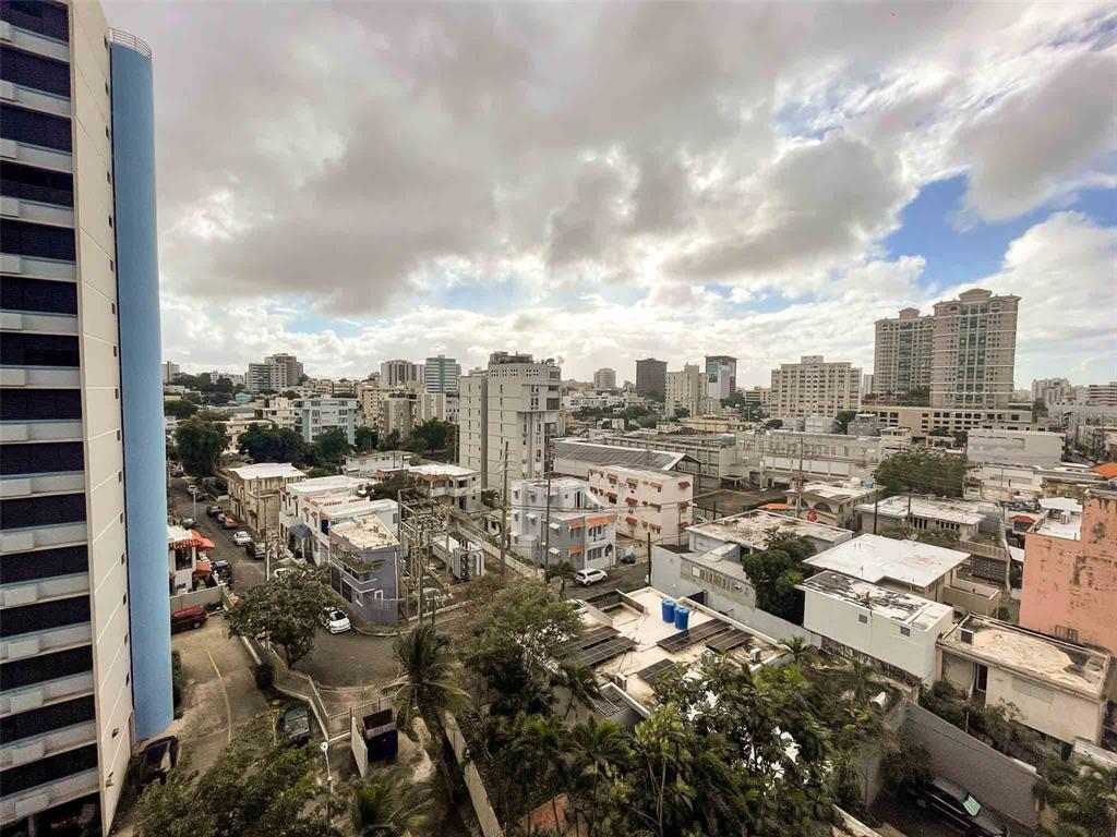 An elevated view of a city skyline with buildings, streets, and trees under a cloudy sky — 1760 CALLE LOIZA UNIT 803, SAN JUAN, PR