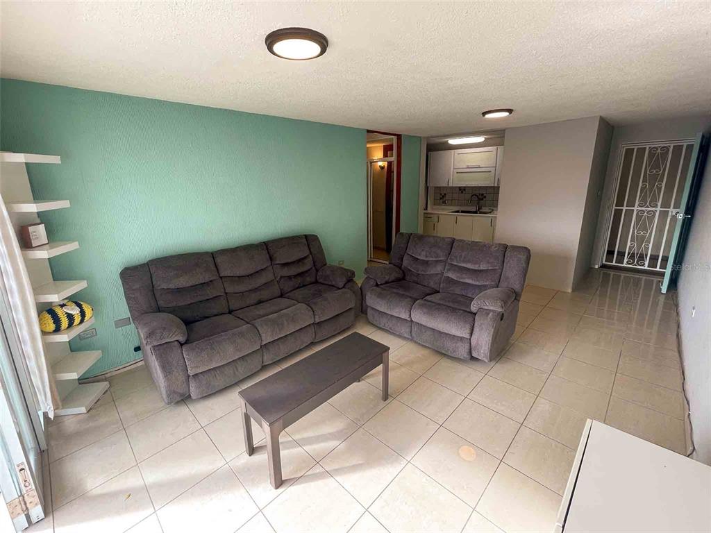 A living room features a gray sofa and loveseat, a coffee table, and tile flooring — 1760 CALLE LOIZA UNIT 803, SAN JUAN, PR