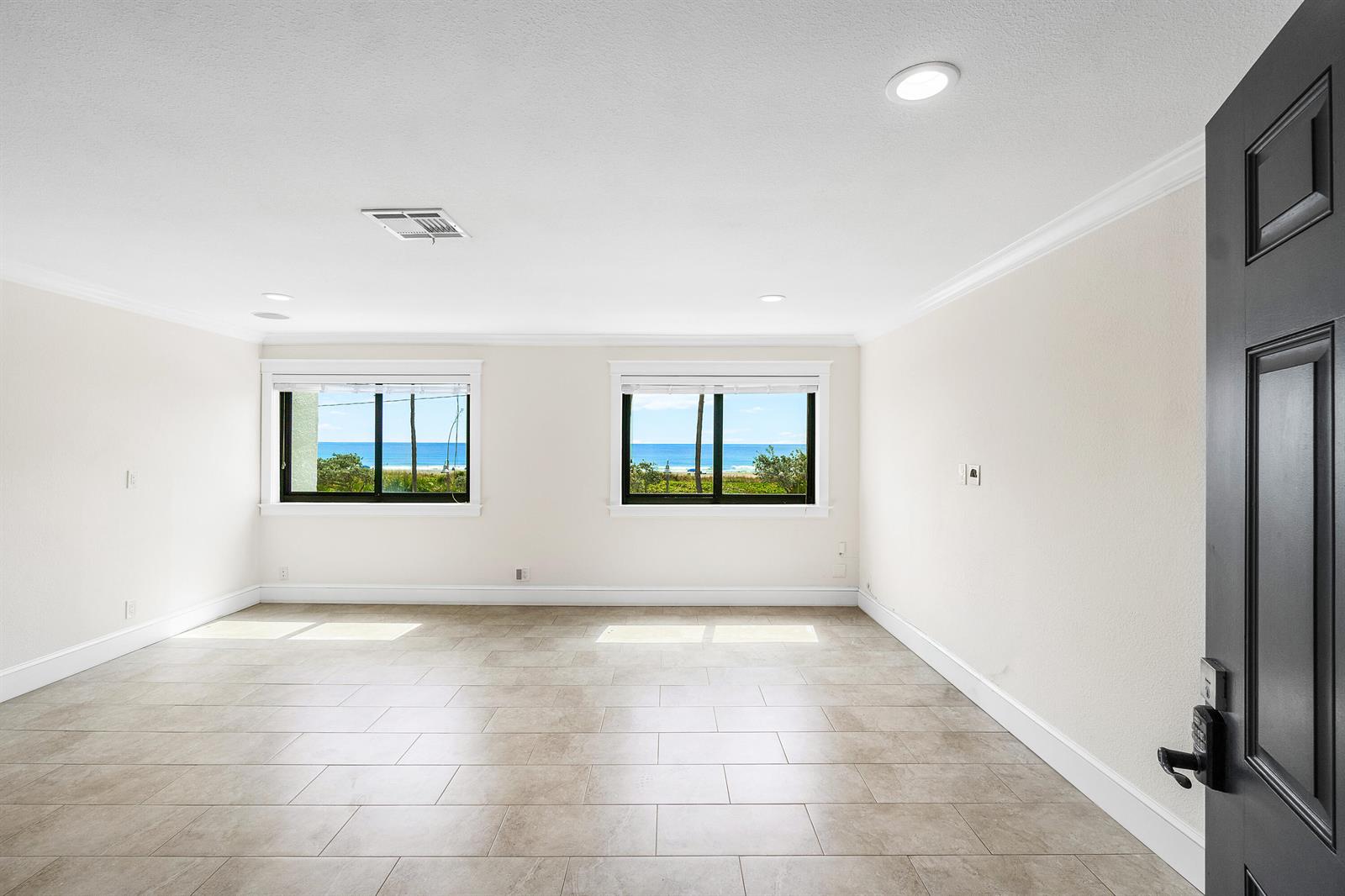 An empty room with light tile flooring, white walls, and two windows overlooking the ocean — 250 S Ocean Boulevard # 253, Delray Beach FL 33483, DELRAY BEACH, FL