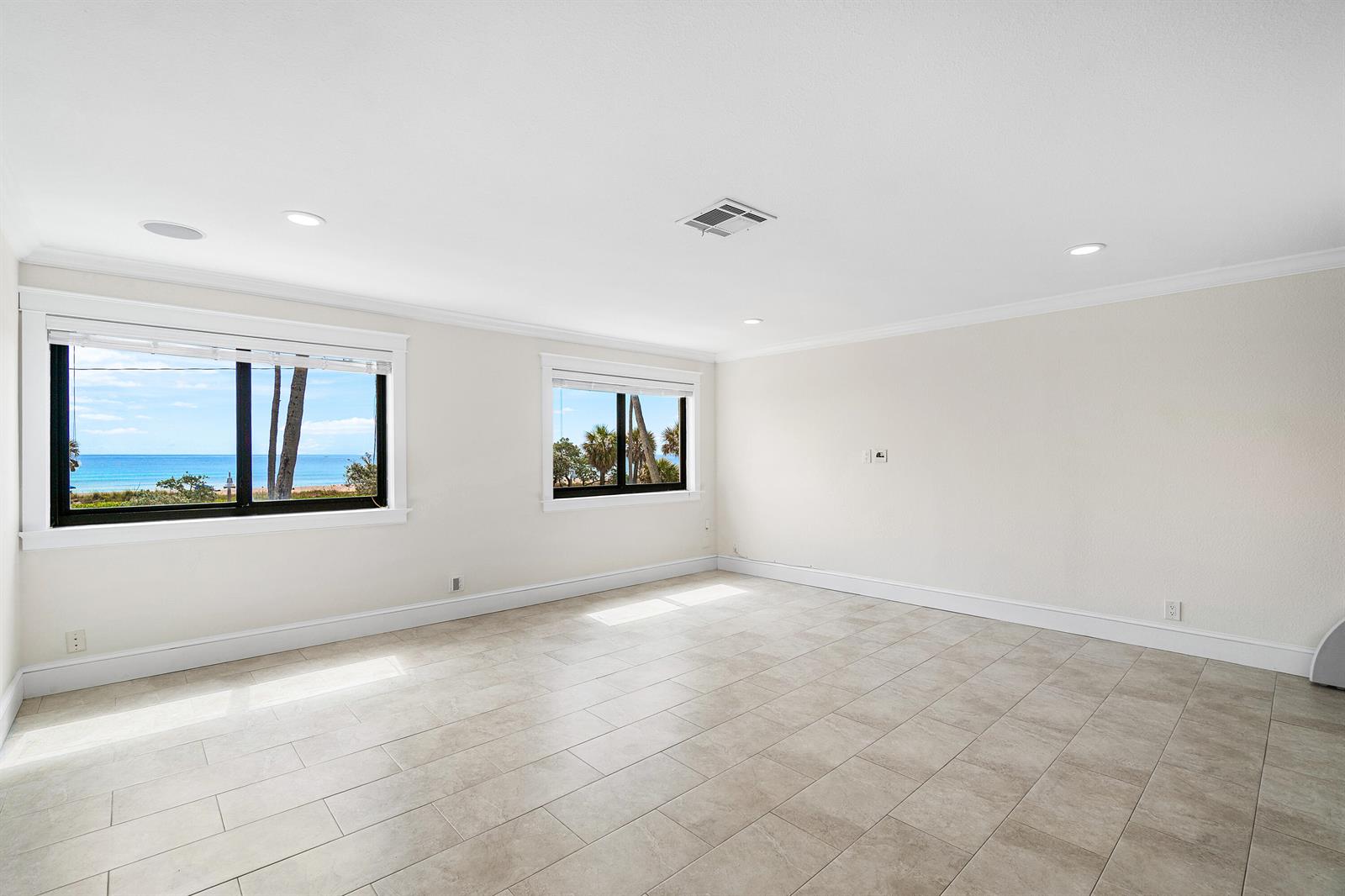 An empty room with light tile flooring, white walls, and windows overlooking the ocean — 250 S Ocean Boulevard # 253, Delray Beach FL 33483, DELRAY BEACH, FL